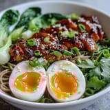 A close view of Healthy Miso Chicken Noodle Bowls garnished with sesame seeds and scallions, served with chili oil and nori strips.