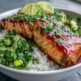 Flaky, paprika-seasoned salmon fillet drizzled with creamy bang bang sauce, served over jasmine rice and fresh cucumber-edamame salsa.