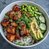 Fluffy jasmine rice topped with marinated baked salmon, crisp cucumber, creamy avocado, and edamame, finished with sesame seeds and spicy mayo.  