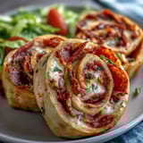 Vibrant Italian Sub Pinwheel Wraps featuring Genoa salami, pepperoni, and provolone rolled in tortillas with tangy peppers and lettuce.