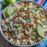 Creamy Mexican street corn pasta salad with charred corn, cotija cheese, and zesty lime dressing in a vibrant bowl.