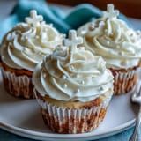 Soft vanilla cupcakes decorated with elegant white fondant cross toppers for First Communion celebrations.