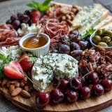 Artisan cheeses, prosciutto, and ripe fruits create a stunning Summer Charcuterie Board with honey.