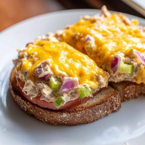 A comforting Tuna Melt recipe featuring creamy tuna salad with celery and red onion, topped with melted cheddar on buttery toasted bread.