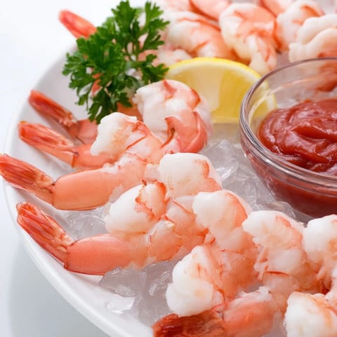 Plump, pink shrimp cocktail served on a bed of crisp lettuce with tangy horseradish-infused sauce and fresh lemon.