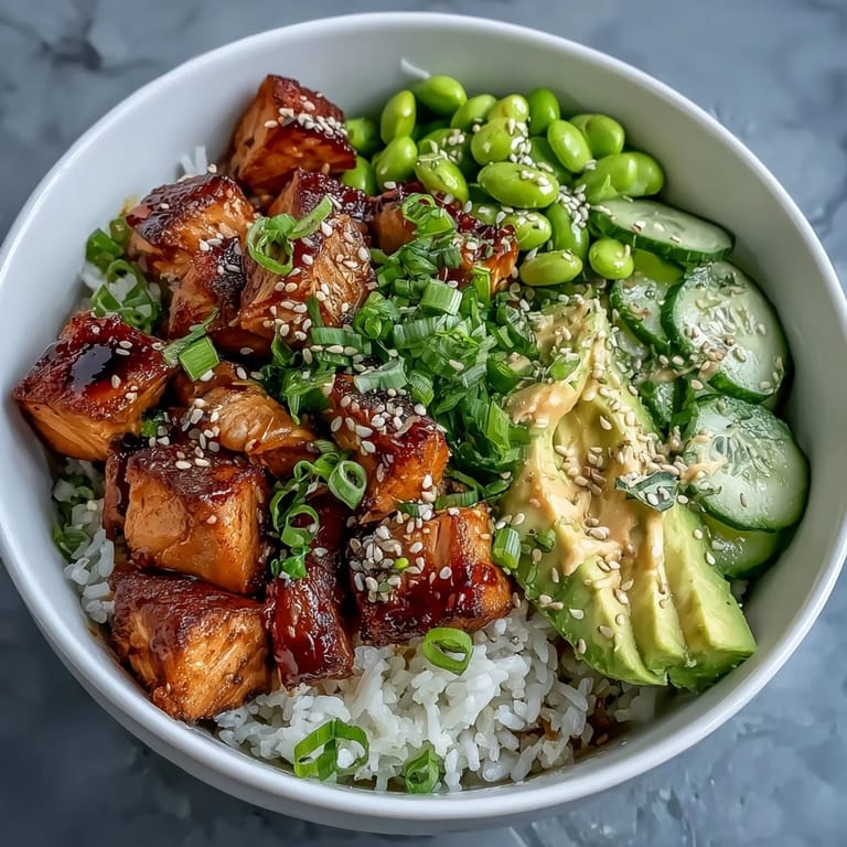 Fluffy jasmine rice topped with marinated baked salmon, crisp cucumber, creamy avocado, and edamame, finished with sesame seeds and spicy mayo.  