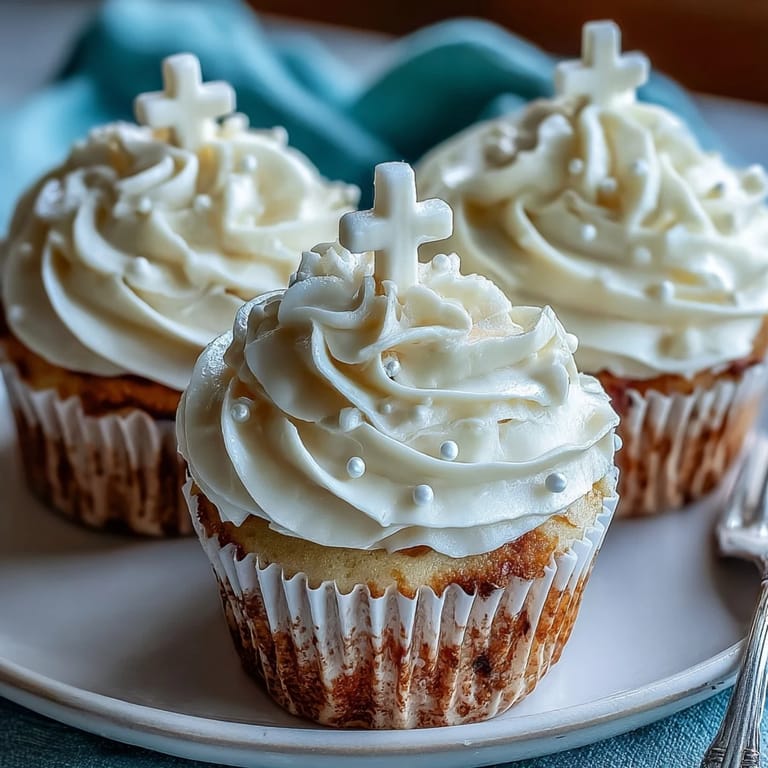 Soft vanilla cupcakes decorated with elegant white fondant cross toppers for First Communion celebrations.