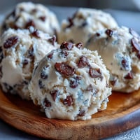 A scoopable portion of Greek Yogurt Cookie Dough shows mini chocolate chips in creamy, buttery dough.